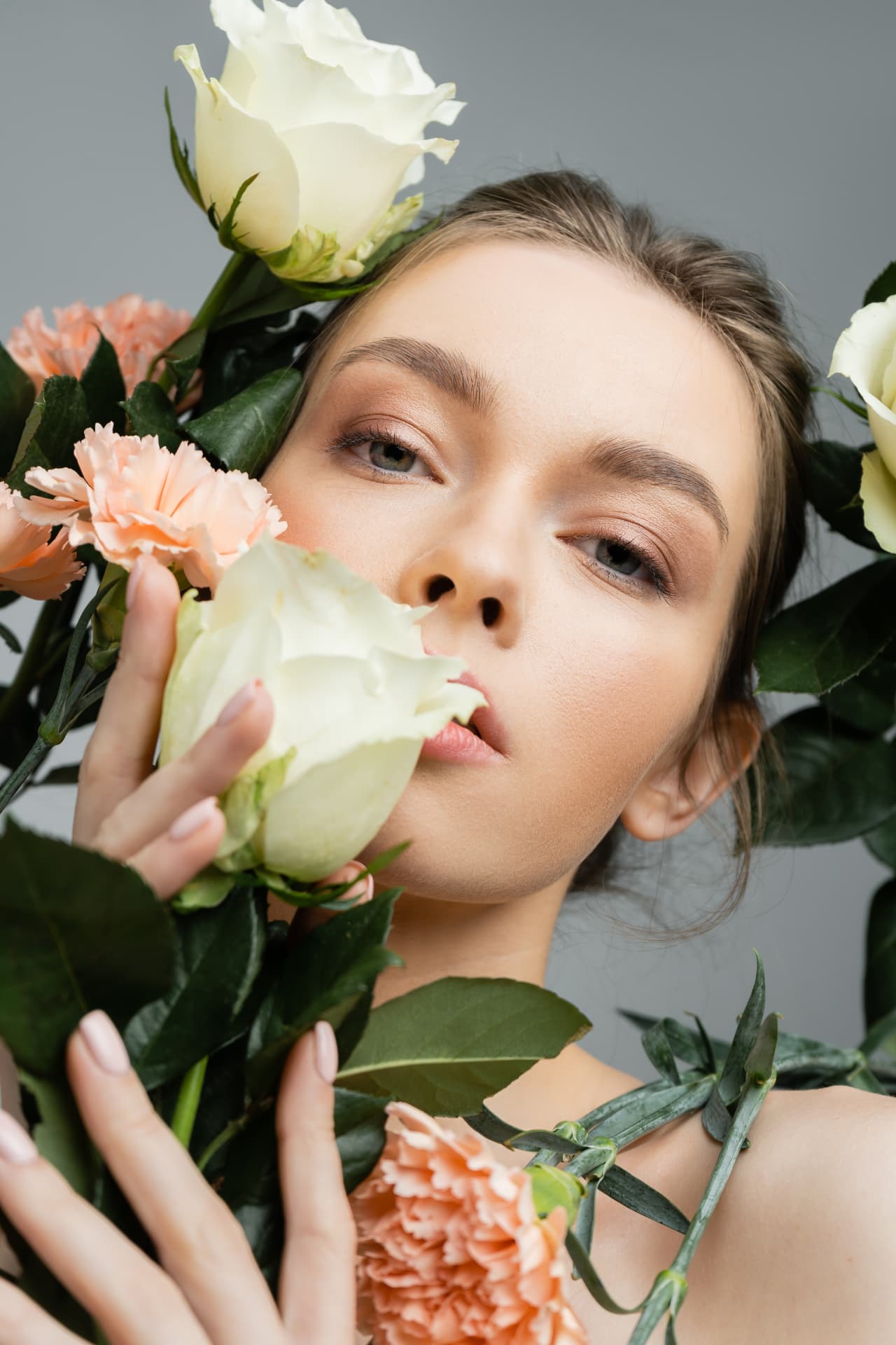 Porträt einer Frau mit weißen Rosen und pfirsichfarbenen Nelken
