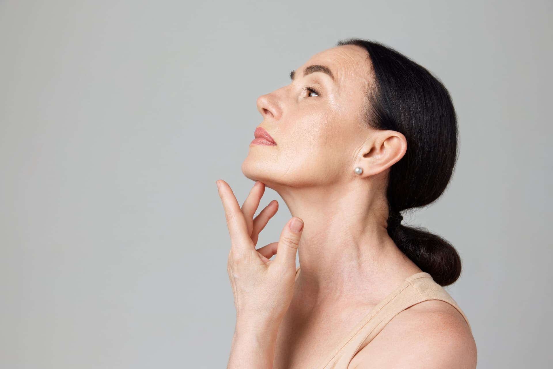 Frau im Profil mit der Hand an Kinnlinie und Hals